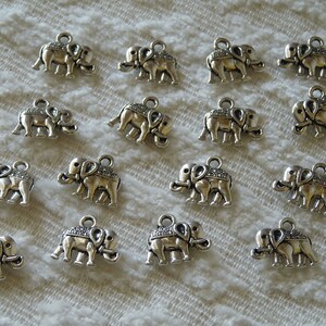K&ouml;nnte beinhalten: Eine Sammlung von 17 silbernen Elefantenanh&auml;ngern. Die Anh&auml;nger sind mit strukturierten Oberfl&auml;chen verziert und haben oben eine &Ouml;se zum Anbringen an Schmuck oder andere Bastelarbeiten.