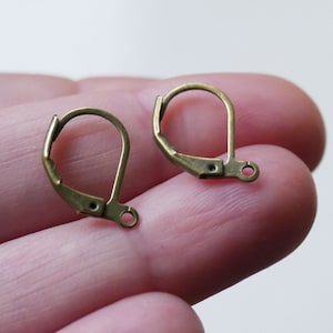May include: Two gold-toned earring hooks with a lever back closure. The hooks are made of metal and have a smooth finish.