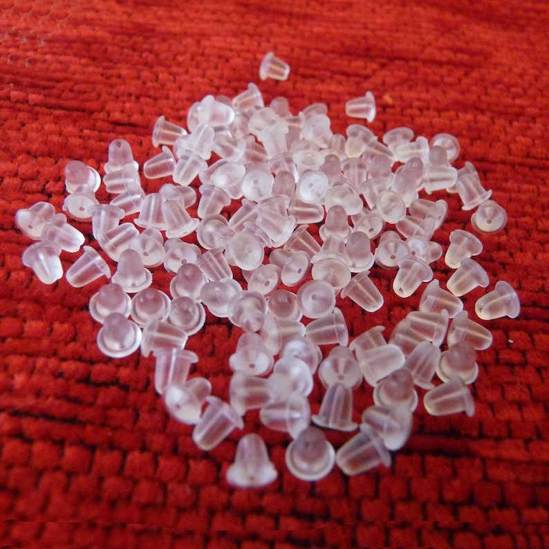 Puede incluir: Un mont&oacute;n de respaldos de pendientes de pl&aacute;stico transparente. Los respaldos son peque&ntilde;os y redondos, con un peque&ntilde;o agujero en el centro. Est&aacute;n dise&ntilde;ados para ser usados con pendientes de bot&oacute;n.