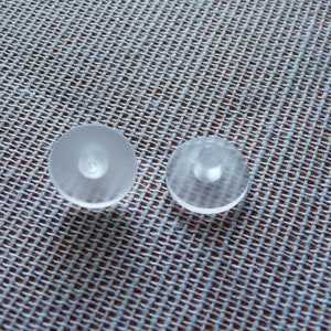 May include: Two clear plastic suction cups, one with a raised center and one with a flat center.