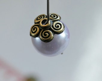 May include: A pearl bead with a gold-toned metal flower charm. The charm has a swirl design.