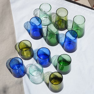 Peut inclure: Assortiment de 12 verres &agrave; boire dans diff&eacute;rentes nuances de bleu, vert et transparent. Les verres sont en verre et ont une surface textur&eacute;e.