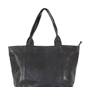 May include: A black leather tote bag with double handles. The bag has a zipper closure and a subtle textured finish.