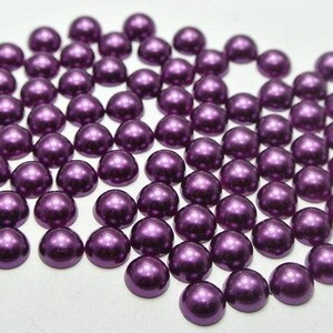 May include: A large quantity of small, round, purple pearl-like beads. The beads have a shiny, metallic finish.