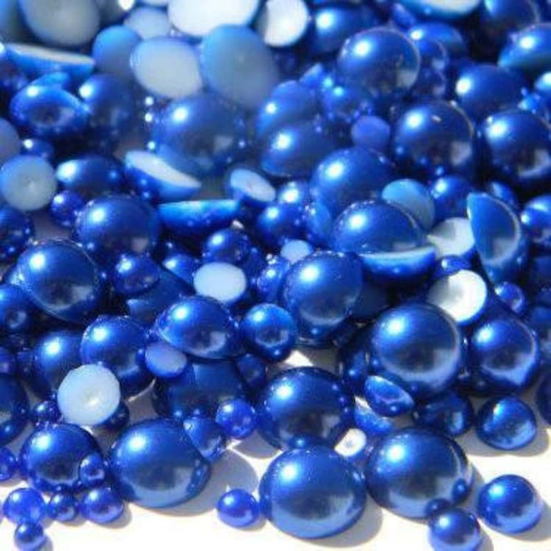 May include: A mix of blue pearl beads in various sizes. The beads are iridescent and have a smooth, glossy finish.