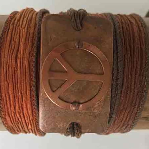 Handmade silk wrap bracelet featuring a vintage copper peace sign on a copper curved rectangle with a beautiful patina on a silk ribbon.