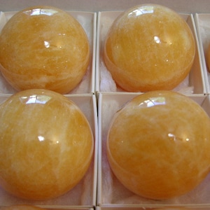 Orange calcite sphere hand carved polished 2+ inch 1 sphere w/ring stand per winner