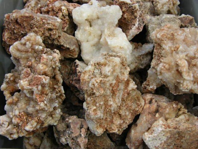 Puede incluir: Primer plano de un mont&oacute;n de rocas &aacute;speras, blancas y marrones. Las rocas tienen una textura cristalina y son de forma irregular.