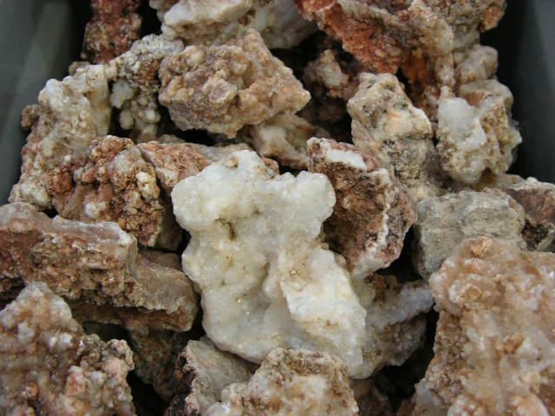 Puede incluir: Primer plano de un mont&oacute;n de rocas &aacute;speras, blancas y marrones. Las rocas tienen una variedad de formas y tama&ntilde;os, y algunas tienen una textura cristalina.