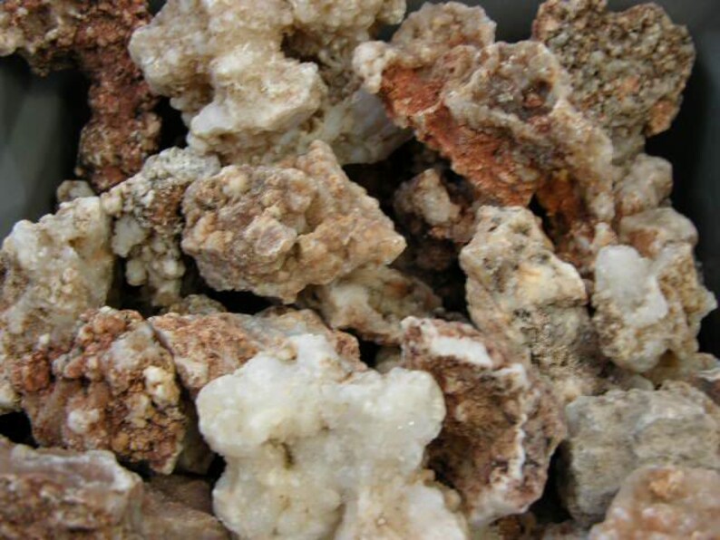 Puede incluir: Primer plano de un mont&oacute;n de rocas &aacute;speras, blancas y marrones. Las rocas tienen una variedad de formas y tama&ntilde;os, y algunas tienen una textura cristalina.