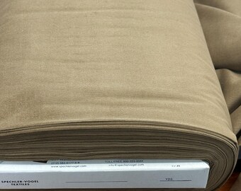 May include: A roll of tan fabric with a ribbed texture. The fabric is tightly rolled, revealing the layers. A white box with the text "SPECHLER-VOGEL TEXTILES" is visible at the base of the roll. The box also includes contact information.