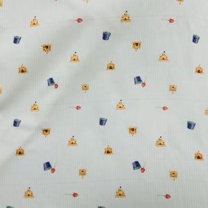 Tessuto con stampa "Castello di sabbia" su seersucker bianco di Fabric Finders