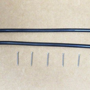 Peut inclure: Deux bandes de caoutchouc noires et six punaises argentées. Les bandes de caoutchouc mesurent environ 30 cm de long.