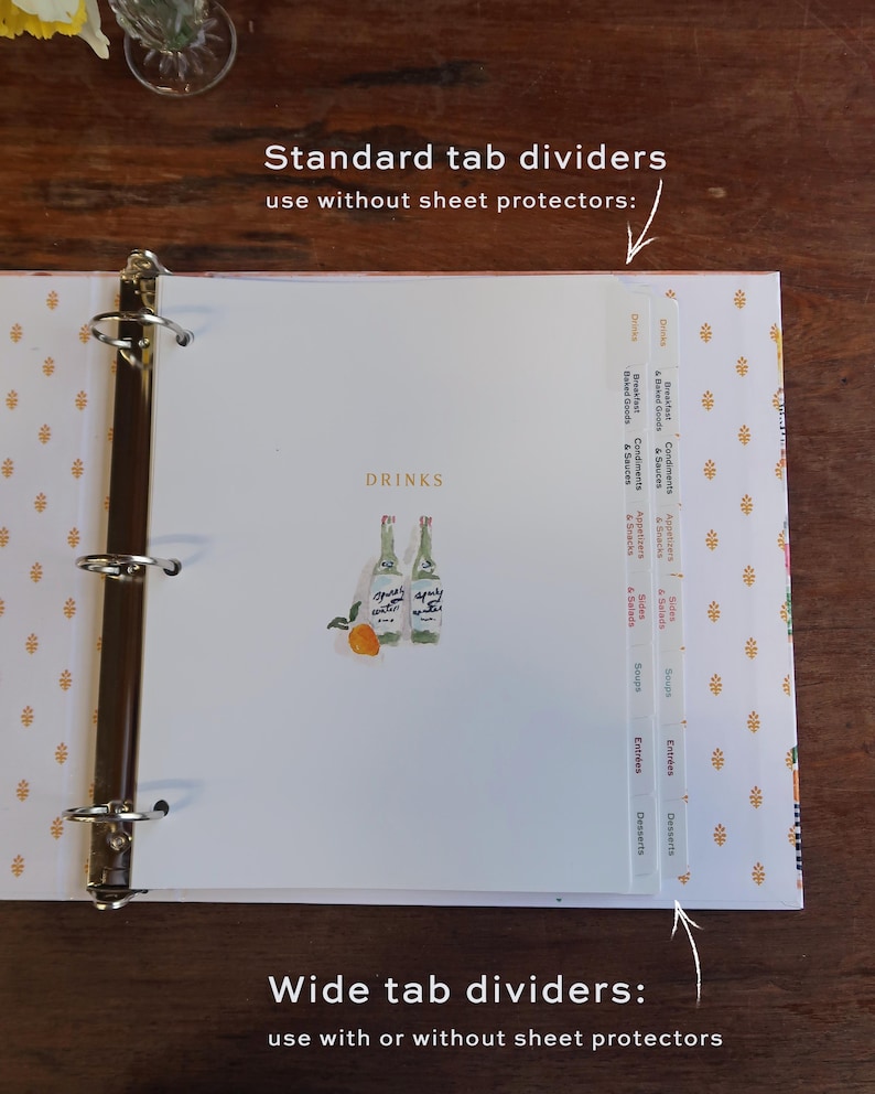 May include: A three-ring binder containing white tab dividers with printed text. The page shows the word DRINKS and an illustration of two bottles and an orange. Text labels indicate Standard tab dividers and Wide tab dividers for use.