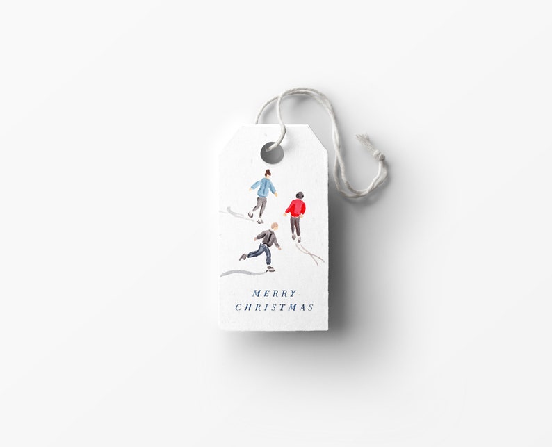 May include: A white gift tag with a watercolor illustration of four people ice skating. The text "Merry Christmas" is printed in blue at the bottom of the tag.