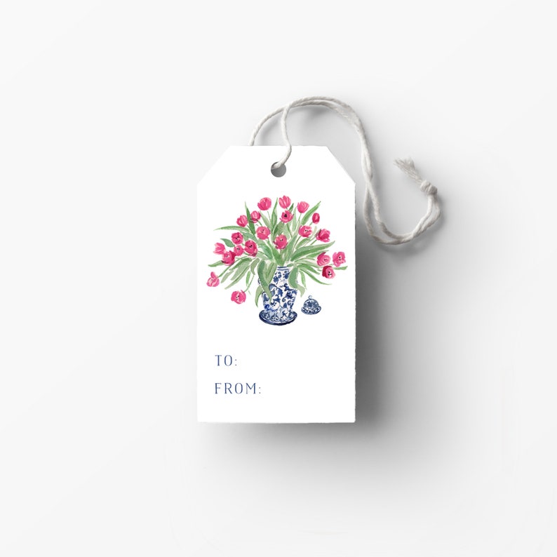 K&ouml;nnte beinhalten: Ein wei&szlig;er Geschenkanh&auml;nger mit einer blau-wei&szlig;en Porzellanvase, gef&uuml;llt mit rosa Tulpen. Der Anh&auml;nger hat die Worte "An:" und "Von:" aufgedruckt.