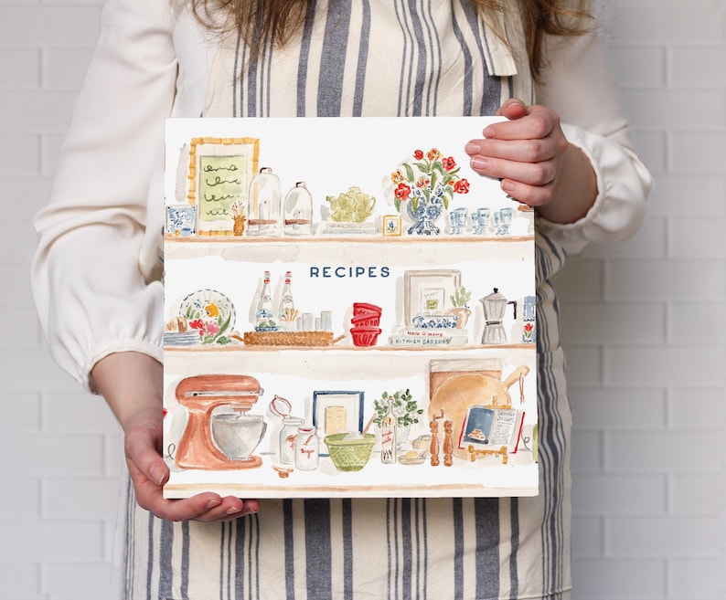 May include: A square recipe book with a white cover featuring a watercolor illustration of three kitchen shelves filled with various items including a stand mixer, bowls, bottles, a vase of red flowers, and the word RECIPES printed in blue.