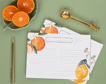 May include: Three recipe cards with a white background and green and orange floral designs. The cards have lines for writing down a recipe, including prep time, total time, servings, and notes.