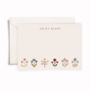 May include: A cream-coloured stationery card and matching envelope. The card features the name JULIET BLAKE printed in red at the top centre and a row of six colourful, detailed floral illustrations in shades of pink, blue, yellow, and red.