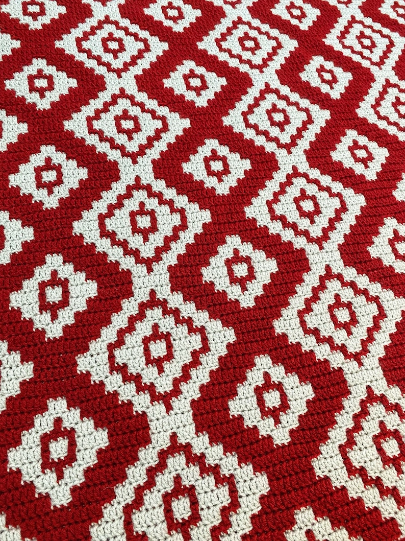 May include: Red and white crocheted blanket with a geometric diamond pattern.
