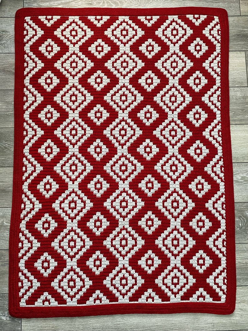 May include: Red and white crocheted rug with a geometric diamond pattern.