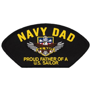 May include: Black embroidered patch with yellow text that reads "Navy Dad" and "Proud Father of a U.S. Sailor". The patch features a stylized eagle with wings spread, holding an anchor and a shield with the U.S. Navy logo.