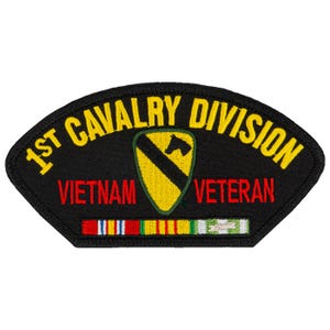 May include: A black patch with yellow text reading "1st Cavalry Division" and "Vietnam Veteran." The patch features a yellow and green shield with a black horse head. Below are colored ribbons.