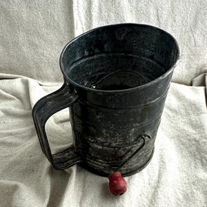 Antique Bromwell's Sifter, 5 1/2" tall x 4 3/8" diameter, red wooden knob on the handle, silver metal, rusty and crusty