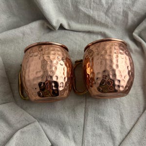 May include: A weathered wooden sign displaying the words "Welcome to our home" in white. The sign has a distressed appearance, suggesting a vintage aesthetic, and is suitable for a porch or hallway.