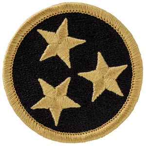 May include: Embroidered patch featuring three gold stars on a black circular background. The stars are evenly spaced and have a detailed, textured appearance. The patch is bordered with a gold, stitched edge.