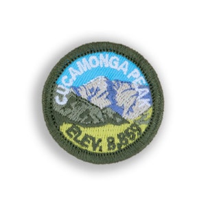 May include: A green embroidered patch with a mountain scene and the text "CUCAMONGA PEAK" and "ELEV. 8,859".