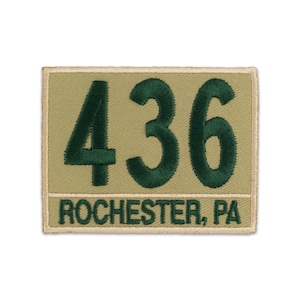 May include: A rectangular embroidered patch featuring a tan background with a dark green border. The patch displays the large dark green numbers 436 above the text ROCHESTER, PA in a smaller dark green font, all stitched with a clean finish.