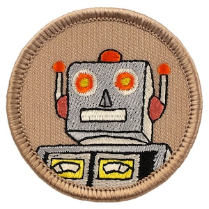 May include: A brown embroidered patch with a cartoon robot with orange, red, yellow, and white details. The robot has a square head with two antennas and two round eyes. The robot's body has two rectangular panels with yellow and white details.