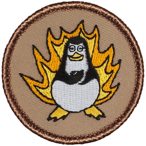 May include: A brown embroidered patch with a cartoon penguin wearing glasses and a black tuxedo, surrounded by yellow flames.