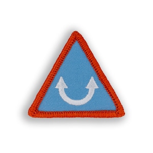 May include: A blue triangular patch with an orange border. The patch has a white embroidered symbol of two arrows pointing upwards, forming a U shape.