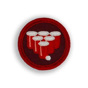 May include: Red and white embroidered patch with a design of a red solo cup game. The patch is circular and has a red border.