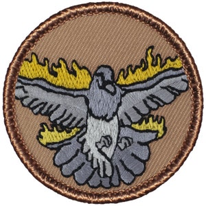 May include: A round embroidered patch with a brown border. The patch features a gray dove with yellow flames around it.