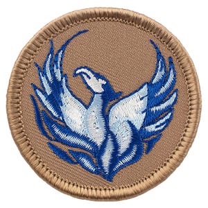 May include: Embroidered patch featuring a stylized phoenix with outstretched wings. The bird is depicted in shades of blue and white against a tan background. The patch has a circular shape with a stitched border, suitable for application on clothing or accessories.