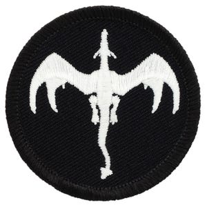 May include: White embroidered dragon on a black circular patch. The dragon is facing upwards with its wings spread out.