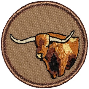 May include: Embroidered patch featuring a brown and white longhorn steer with large horns. The patch is circular and has a brown border.