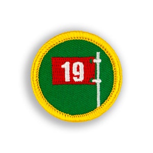 May include: A green and yellow embroidered patch with a red flag with the number 19 on it.