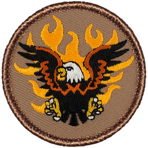 May include: A brown embroidered patch with a black eagle with white head and orange flames behind it.