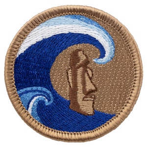 May include: Embroidered patch featuring a brown moai statue with a blue and white wave behind it. The patch is circular and has a tan border.