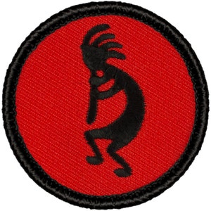 May include: A red and black embroidered patch featuring a Kokopelli silhouette. The Kokopelli is a flute-playing spirit figure from Native American folklore.