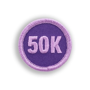 May include: Purple round patch with white stitching around the edge. The patch has the number 50K embroidered in pink.