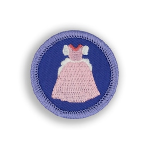 May include: A purple embroidered patch with a pink dress on a blue background.