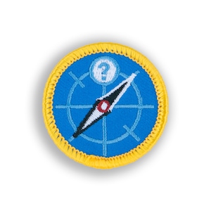 May include: A blue and yellow embroidered scout patch with a compass and a question mark in the center.
