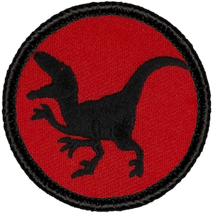 May include: Black embroidered patch of a velociraptor on a red background with a black border.