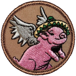 May include: A brown embroidered patch with a pink pig wearing a green sombrero with a yellow band and white wings.