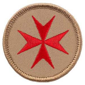 May include: A round, tan embroidered patch with a red Maltese cross in the center.